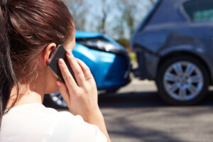 woman using phone after car accident that with Affordable Car Insurance in Logansport, IN