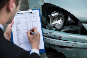 insurance agent documenting vehicle damage after accident with Affordable Car Insurance in Westfield, Indiana